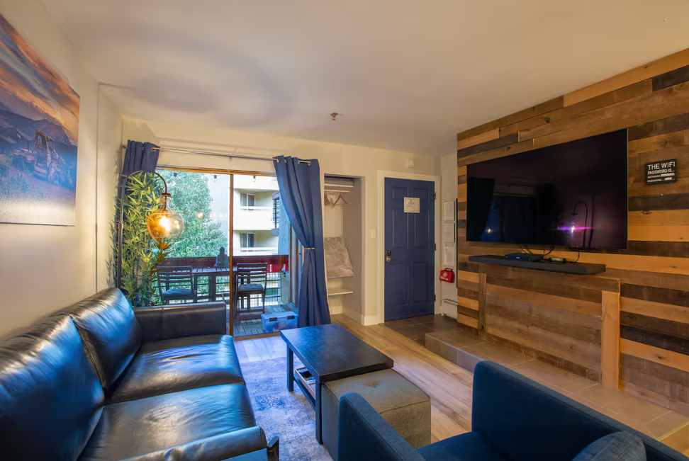 Living room with private mountain view balcony at 11 Emmons Road Crested Butte ski rental